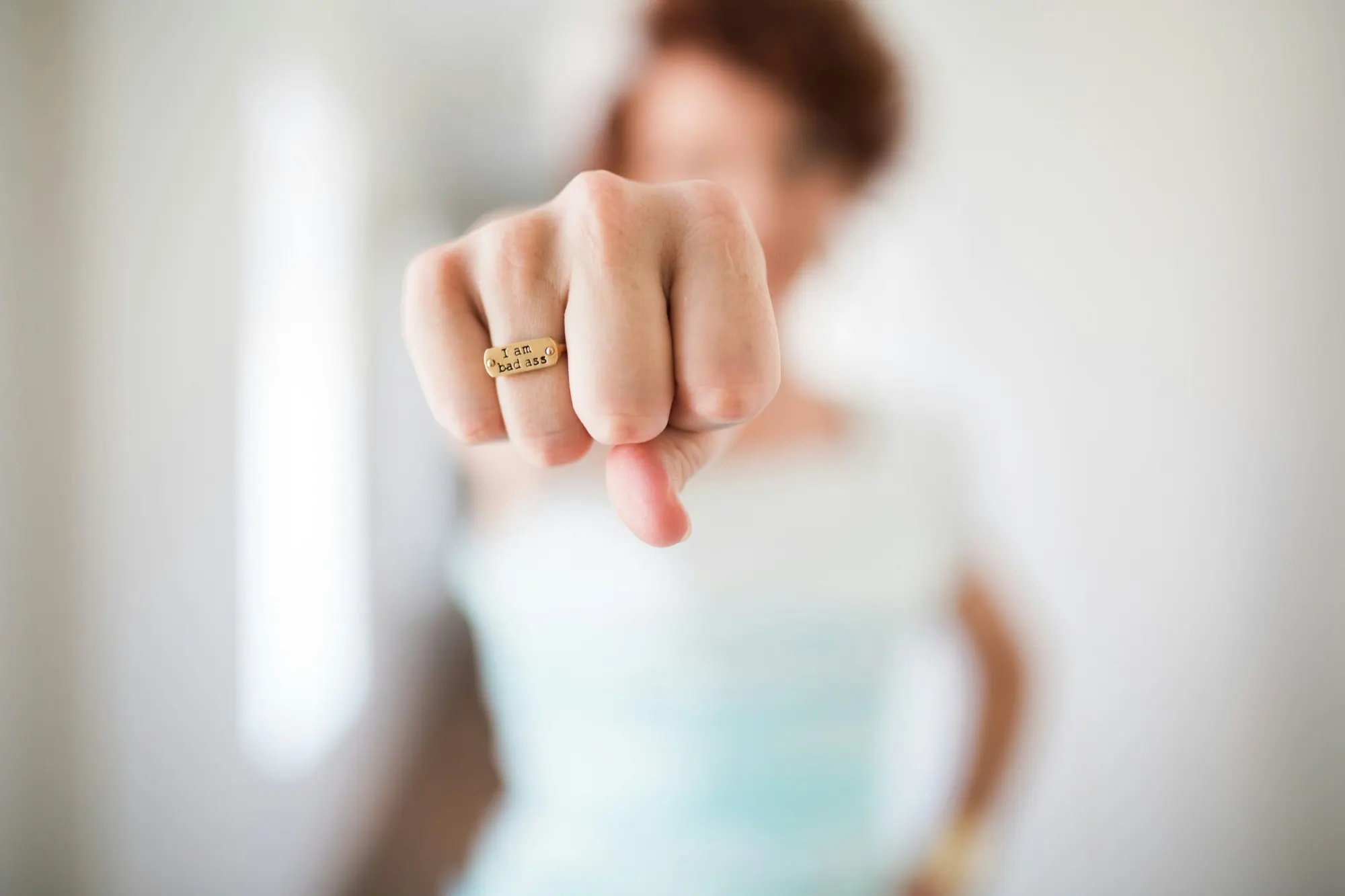 Eine Frau streckt die Faust in die Kamera, auf ihrem Ring steht: I am bad ass